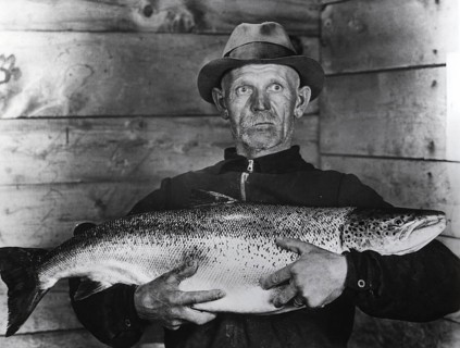 Fisherman with large salmon, presumably a king salmon or quinnat (Oncorhynchus tshawytscha), ca.