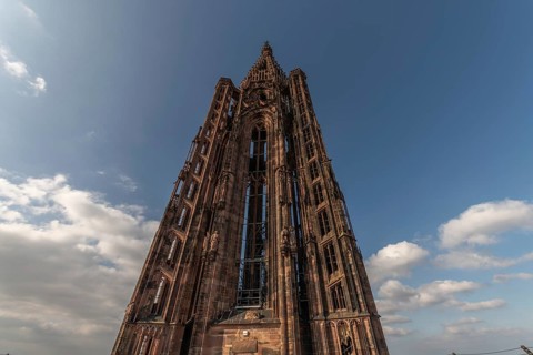 Strasbourg's Gothic cathedral stands majestically under a cloudy sky and gives the scene a unique