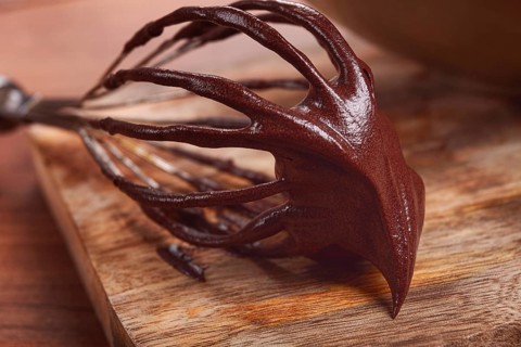 Metal whisk, close-up with chocolate dough, baking, structure and consistency, homemade, top view,