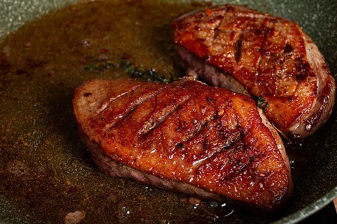 Cooking duck breast, in a frying pan, fried, with spices and herbs, close-up, no people