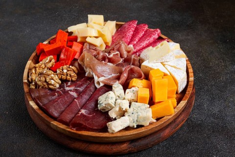 Assortment of cheese meat cuts, on a plate, top view, no people