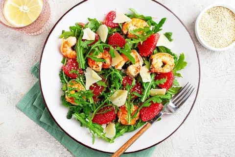 Fresh shrimp salad with arugula, grapefruit, and parmesan served in a bowl