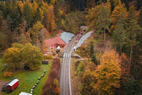 Railway line with tunnel construction, surrounded by autumnal forests and landscape panorama,