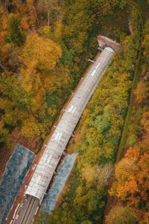 Aerial view of a railway line with tunnel surrounded by autumn trees, Hermann-Hesse-Bahn