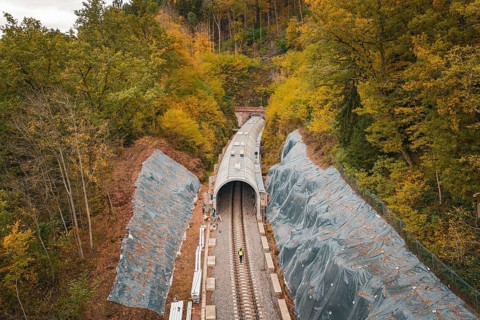 Tunnel construction along the railway line with construction workers surrounded by autumn leaves,