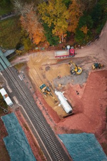 Construction work with heavy machinery on a railway line in autumn forest, Hermann-Hesse-Bahn