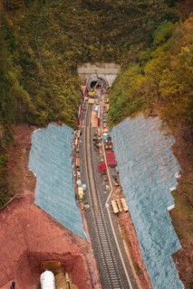 Rail construction in the forest with tunnel opening, surrounded by autumn leaves,