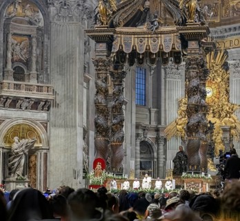 View of heads of faithful in the foreground at the bottom of the picture is Pope Saint Father with