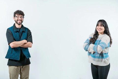 Cheerful young multiethnic couple with arms crossed, isolated. Smiling young couple with crossed