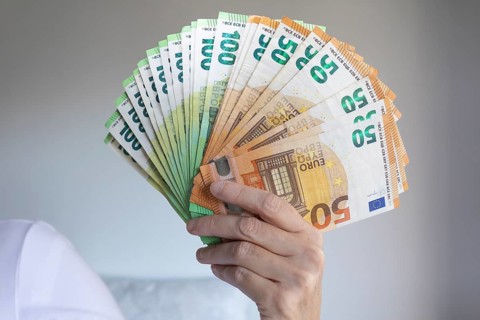 Human hand with several 50 and 100 euro banknotes