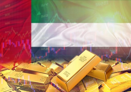 Gold bars on United Arab Emirates flag in background. Gold bars stacked on Emirati flag. Concept of