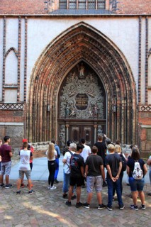 Tourist group in front of the portal of St. Nicholas Church, also St. Nicholas Church, in the city