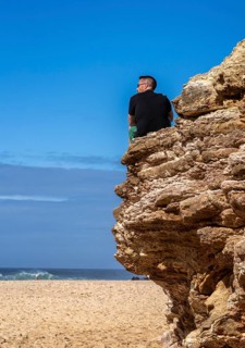 Tourists watch the waves of the Atlantic on the rocky plateau of Sito, also known as Forte São