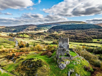 Autumn colours over Castell Dolwyddelan and Eryri Mountains from a drone, Snowdonia, Conwy County