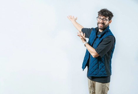 Smiling Handsome Man Presenting something isolated. Handsome guy welcoming you on isolated