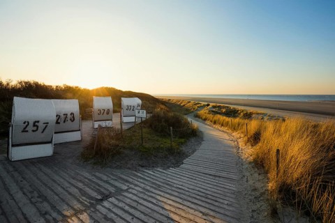 Beach chairs in the dunes and blue sky in winter, sunset, Spiekeroog, East Frisian Islands, Lower