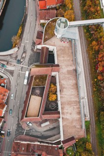 Aerial view of a building complex at an intersection with bridge and railroad tracks in autumn, ZOB