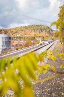 Railway line along autumnal mountain landscape with modern architecture, ZOB Calw, Hermann