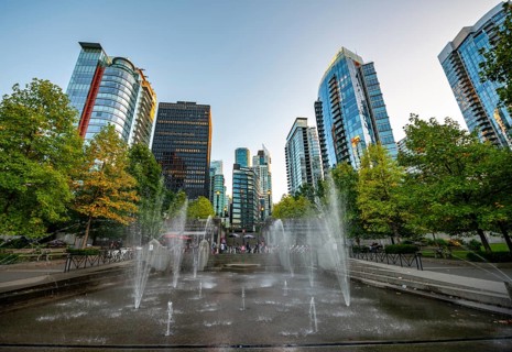 Fountain in Spray Park and SkyLine with skyscrapers at sunset, Harbour Green Park, Vancouver,