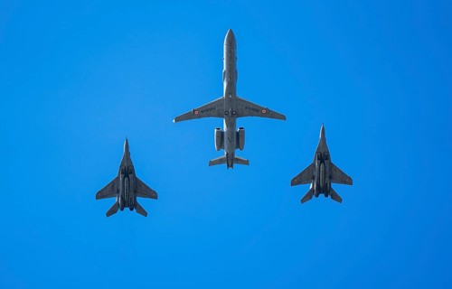 An Indian Air Force Netra AEW&C aircraft flies in formation with two MiG-29 fighter jets during an