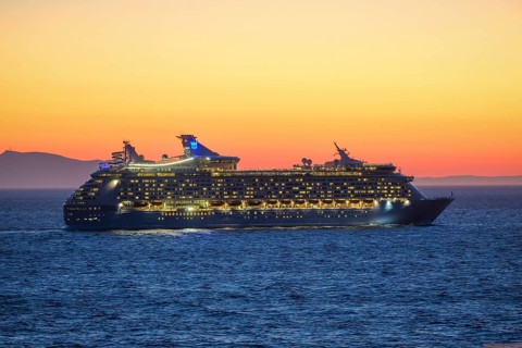 Mykonos, Cyclades, Greece - Voyager of the Seas cruise ship sails from Mykonos harbour bay towards