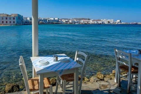 Mykonos, Cyclades, Greece - Small picturesque tavern right on the waterfront, on the harbor in the
