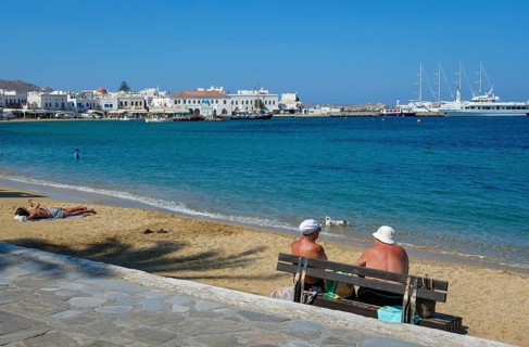 Mykonos, Cyclades, Greece - Tourists and locals like to bathe on the small town beach Paralia Chora