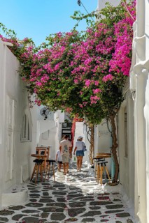 Mykonos, Cyclades, Greece - Tourists stroll through colorful alleys of the old town in Mykonos Town