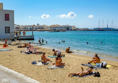 Mykonos, Cyclades, Greece - Tourists and locals like to bathe at the small town beach Paralia