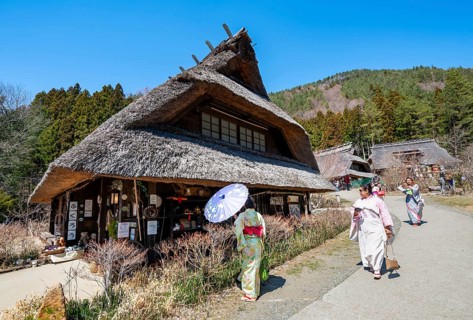 Visitors in kimono, Iyashinosato open-air museum, old Japanese village with traditional houses,
