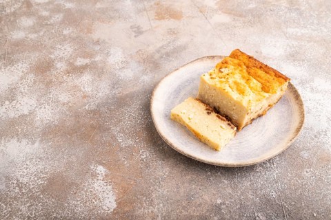 ?ottage cheese ?asserole, Curd cake, with dried apricots and raisins on brown concrete background,