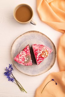 Chocolate cake on white wooden background and orange linen textile, cup of coffee, top view, flat