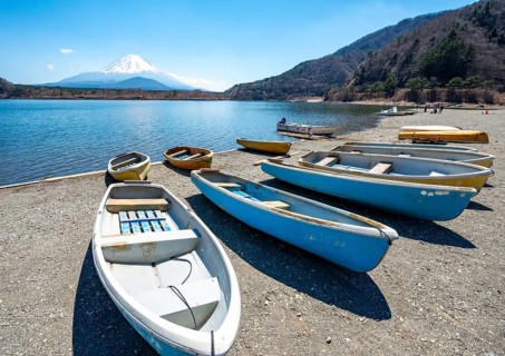 Rowing boats on shore, view across the lake to Mt Fuji volcano, Motosu Lake, Yamanashi Prefecture,