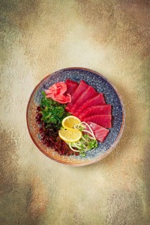 Tuna sashimi with daikon and wakame salad, pickled ginger, in a bowl