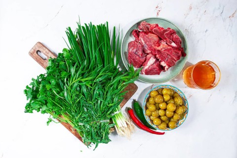 Ingredients for cooking chakapuli, canned tkemali, meat, herbs Georgian cuisine, top view