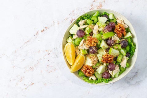 Fresh Waldorf salad, celery stalk with chicken, apple and walnuts, grapes, herbs, homemade, without