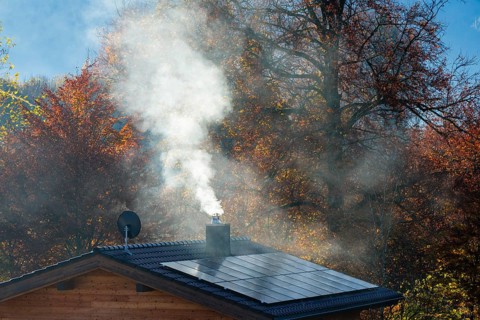 White smoke from fireplace on roof with solar cells, Bischofswiesen, Berchtesgadener Land, Upper