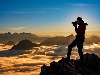 Photographer in evening light at the summit, view of an alpine panorama, Hochstaufen, Chiemgau