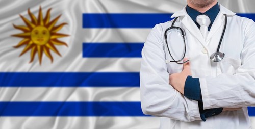 Male doctor with stethoscope on Uruguay flag. Doctor holding stethoscope on Uruguay flag