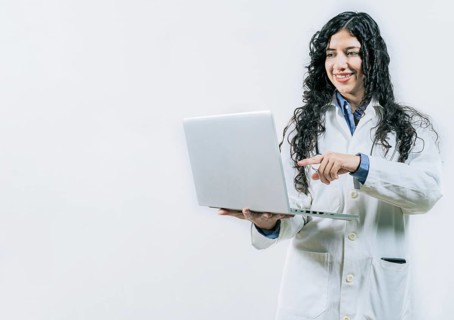 Smiling Woman doctor using laptop on isolated background. Female young doctor using and pointing