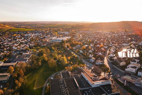 View over the rooftops of a city in autumn evening with lots of nature, Grossbottwar, Germany