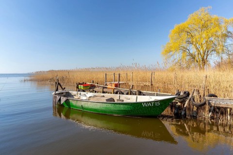 Fishing boat moored at wooden jetty at the Lieper Winkel peninsula near Rankwitz on Usedom island