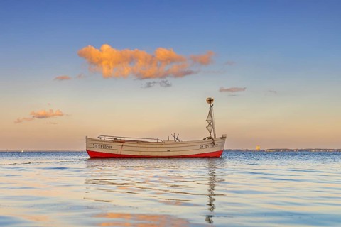 Wooden fishing boat anchored in the Bay of Lübeck, Lübecker Bucht in front of Sierksdorf at sunset,