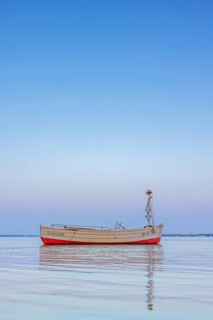 Wooden fishing boat anchored in the Bay of Lübeck, Lübecker Bucht in front of Sierksdorf at sunset,