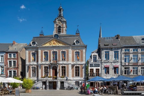 Pavement cafés and 18th century town hall at the Grand Place in the city Huy in summer, province of