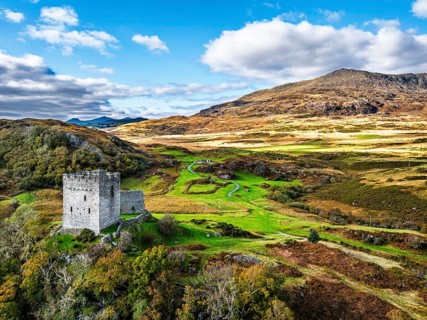 DefaAutumn colours over Castell Dolwyddelan and Eryri Mountains from a drone, Snowdonia, Conwy