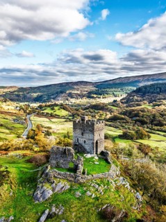 Autumn colours over Castell Dolwyddelan and Eryri Mountains from a drone, Snowdonia, Conwy County