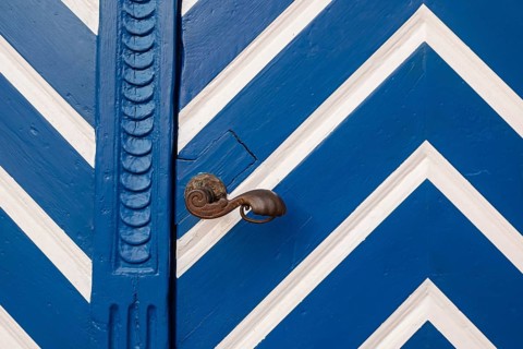 Blue door with white zigzag pattern and antique door knob, Münsterland, North Rhine-Westphalia,