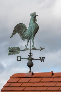 Rooster on metal weather vane on a tiled roof, clouds in the background, Baden-Württemberg, Germany