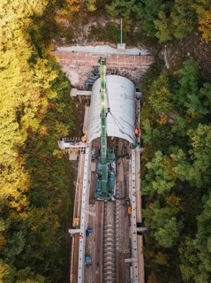 Drone photo of a crane working on a tunnel structure in an autumn environment, built by Hermann,